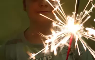 Uczeń trzymający w ręku zimne ognie.