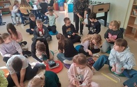 nauczyciel rozdaje uczniom  tasiemnki