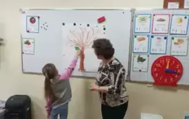 1 uczennica przywiesza listek ze swoim imieniem na klasowym drzewie genealogicznym