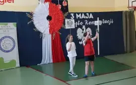 Występ artystyczny - chłopiec trzyma tabliczkę z napisem Gniezno.