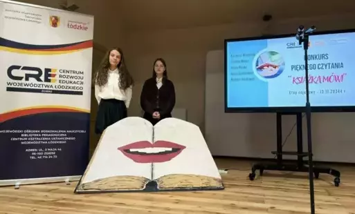 Dwie uczennice stoją na scenie przy dekoracji. 