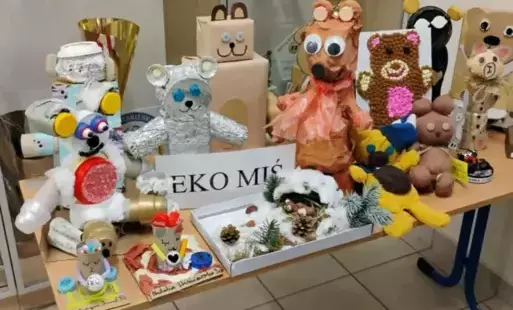 Napis drukowany "Eko miś", prace uczniów wykonane z materiałów recyklingowych. 