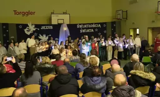 Zdjęcie przedstawia aktorów na scenie oraz rodziców siedzących na widowni. 