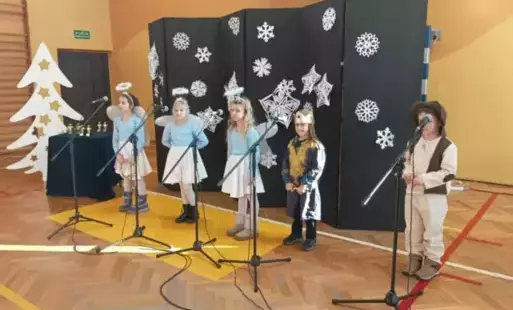 Piątka uczniów przed mikrofonami