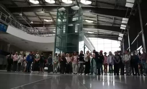 Uczniowie pozują w budynku portu lotniczego. 
