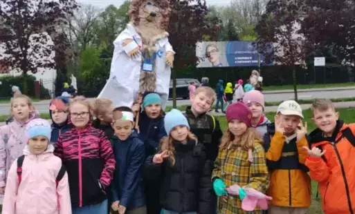 Uczniowie pozują z wykonanym plastycznie jeżem ubranym w biały kitel.