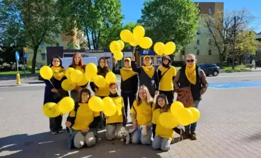 uczniowie w żółtych koszulkach i z żółtymi balonami pozują wraz z nauczycielkami-opiekunkami akcji.