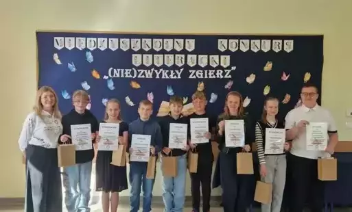 Laureaci konkursu i pani dyrektor pozują na tle dekoracji.