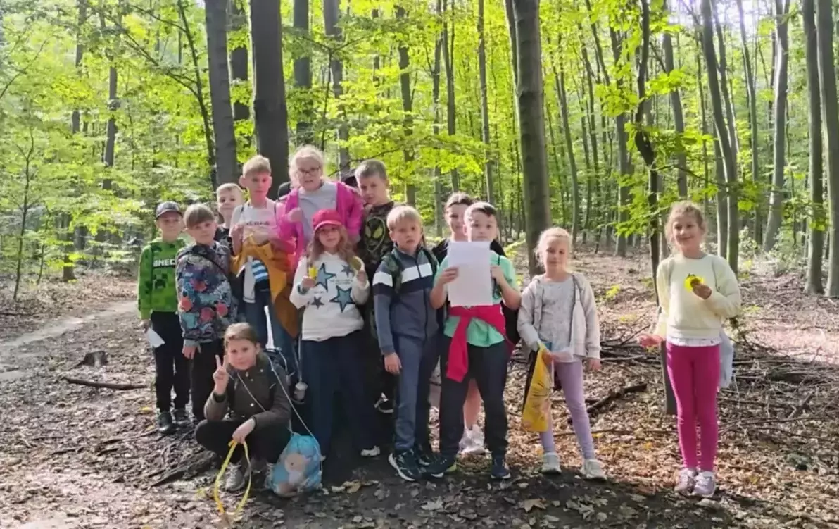 Uczniowie klasy 3b pozują w lesie 