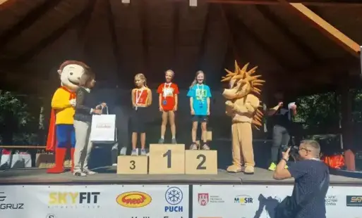 Podium na scenie w Parku Miejskim, nasza uczennica w niebieskiej koszulce na drugim miejscu 