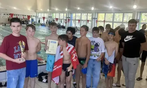 uczniowie na basenie pozują w ręcznikach i kąpielówkach