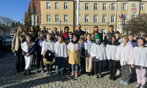 uczniowie z białymi akcentami pozują przed ratuszem 