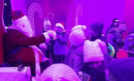 Dzieci i mikołaj, wszystko spowite fioletowym światłem. 