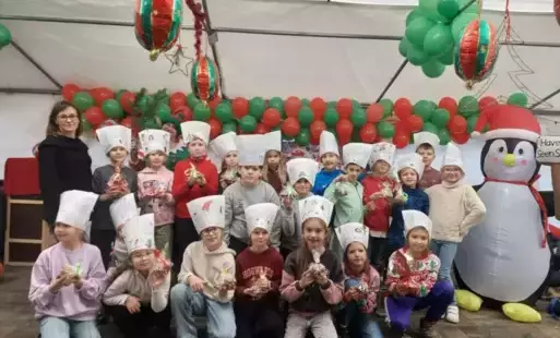 uczniowie 3b pozują z dmuchanym pingwinem, ubrani w czapki kucharskie. 